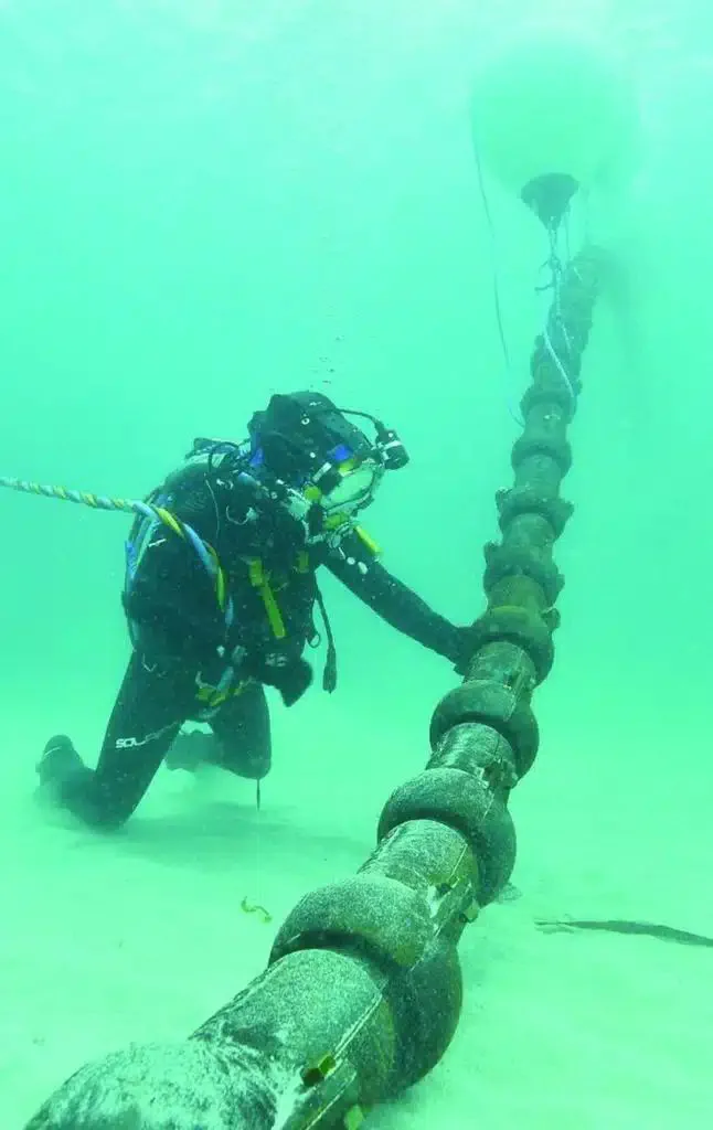 Sanayi dalgıcının deniz tabanında boru hattı üzerinde çalışması